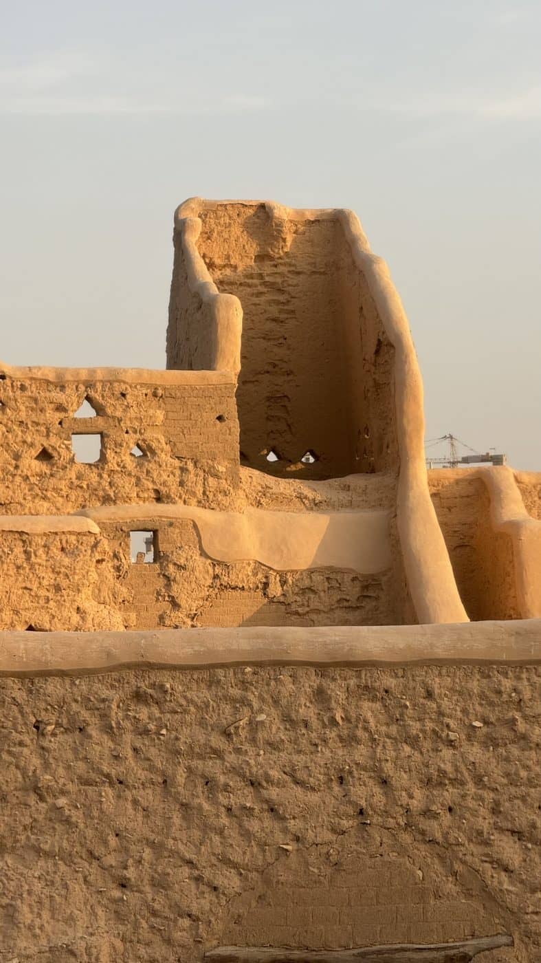 A mud-brick tower against a pale sky